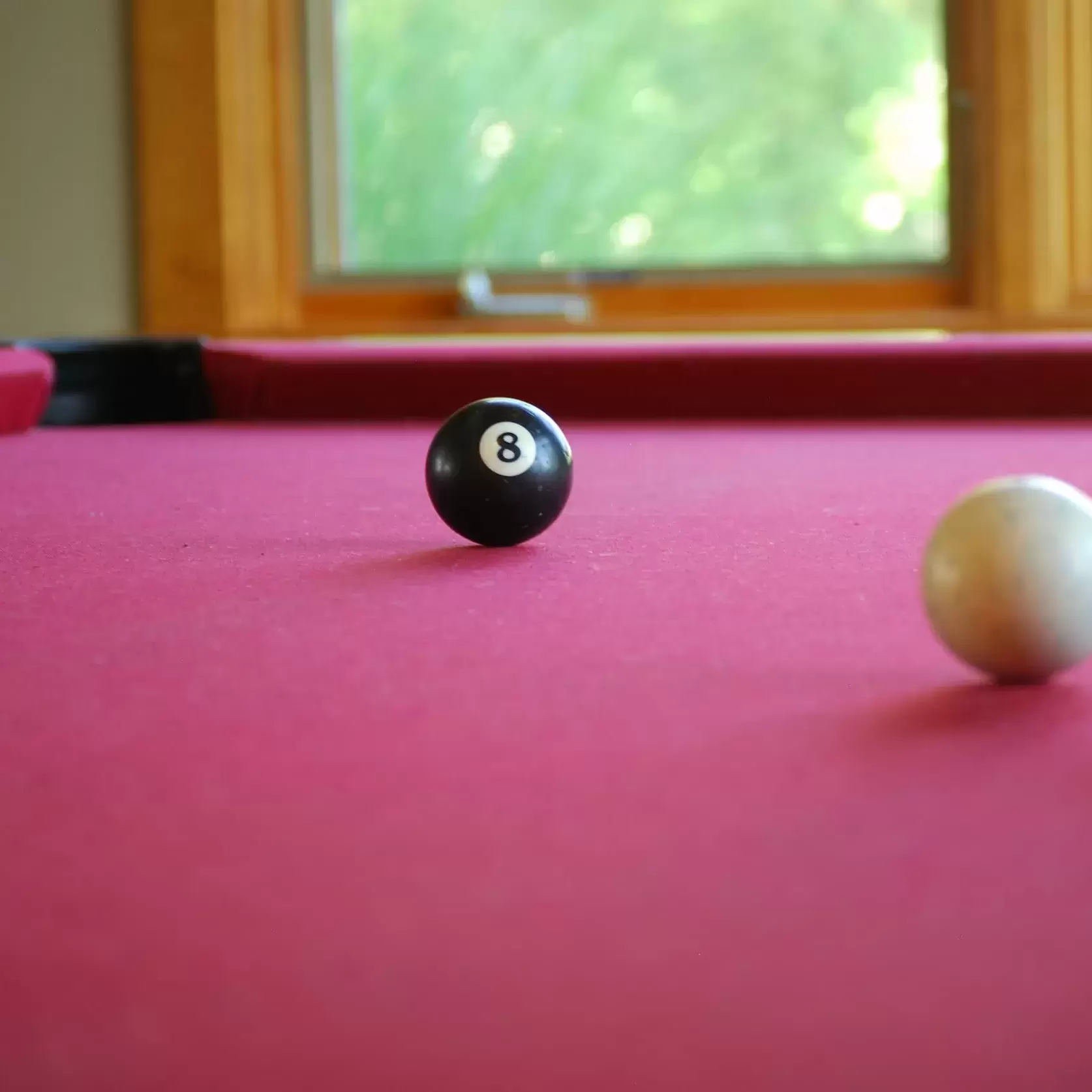 The 8 ball near the pocket on the pool table in the Resident Hub.