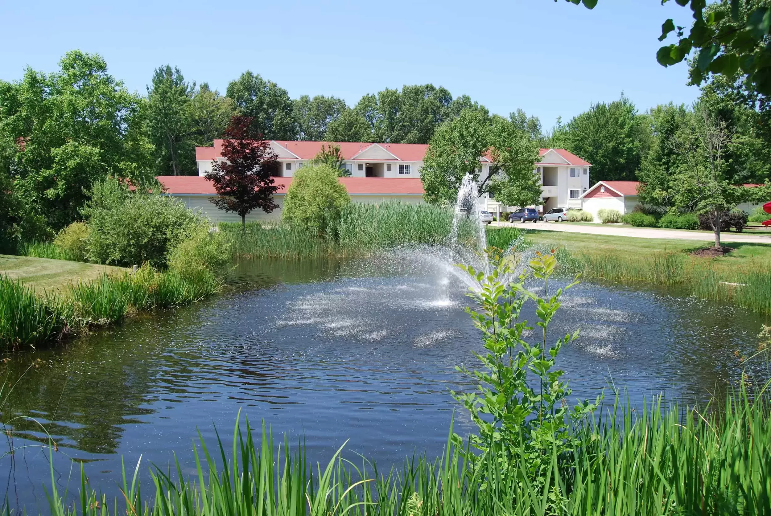 A fountain in a pond creates a beautiful view in front of the Liv Wildwood apartment complex.