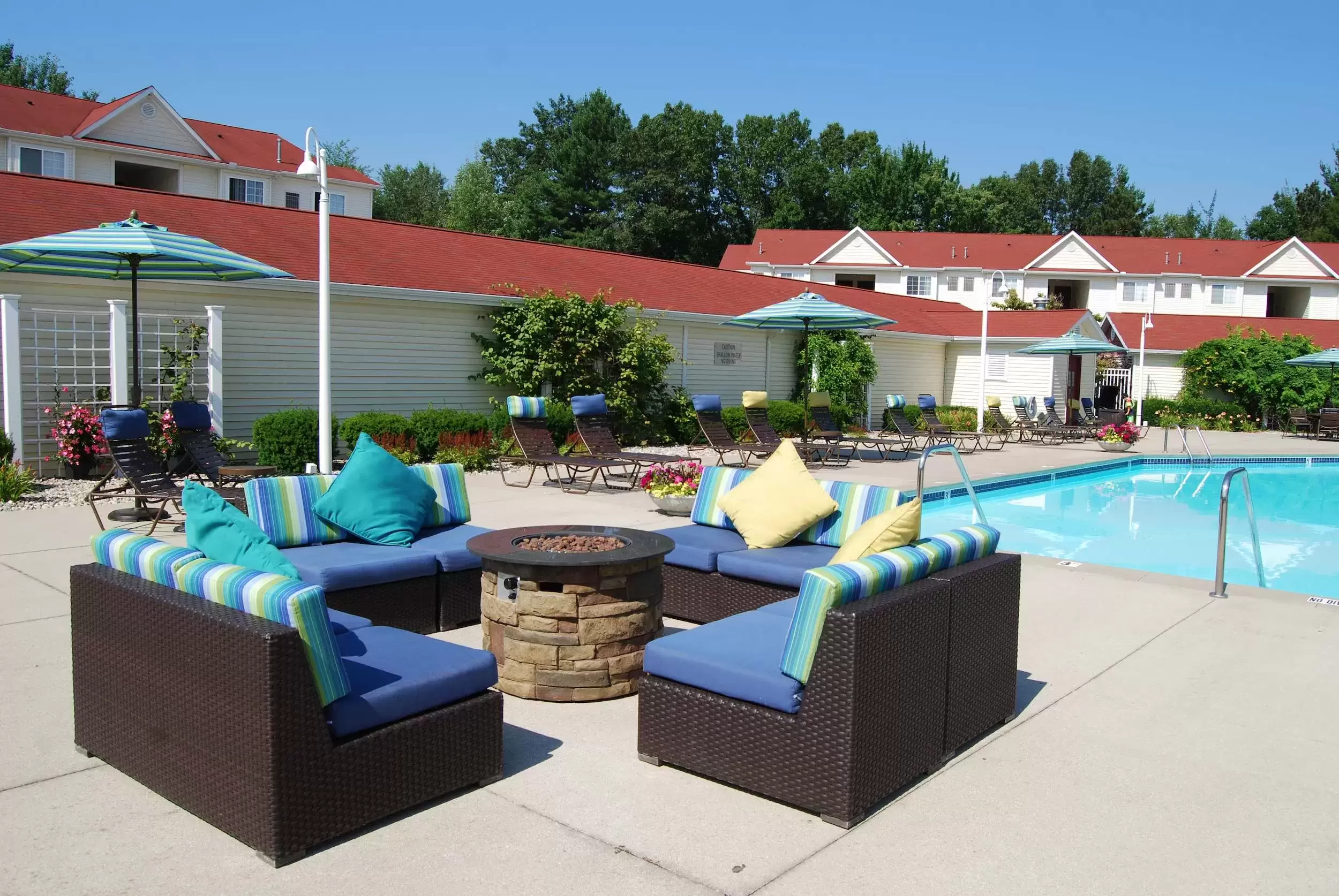 An outdoor seating area by the fire pit on the patio by the pool.